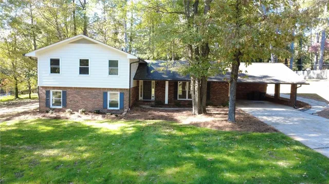 a front view of a house with a yard and trees