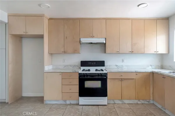 a view of a kitchen with wooden cabinet and windows