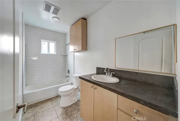 a bathroom with a granite countertop sink mirror and toilet