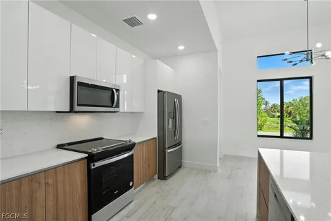 a kitchen with stainless steel appliances granite countertop a stove a microwave and a refrigerator