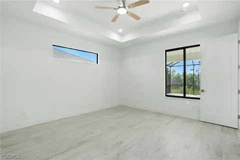 an empty room with a window and a ceiling fan