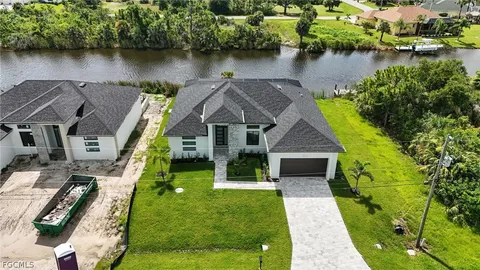 an aerial view of a house with swimming pool and lake view