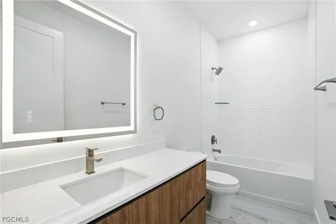 a bathroom with a sink toilet vanity and shower