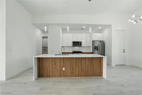 a large kitchen with stainless steel appliances a refrigerator and a stove