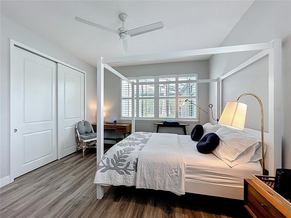 10220 Bay Lake Road Groveland, FL 34736 - Photo 36 of 67 a bedroom with a bed and wooden floor
