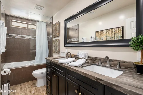 a bathroom with a granite countertop sink mirror and toilet