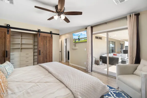a bedroom with a bed a walk in closet and a couch