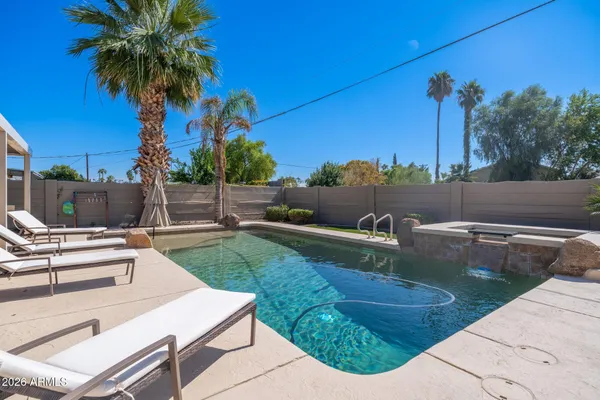 a view of a backyard with couches and swimming pool