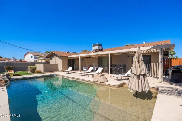 a view of a patio with table and chairs under an umbrella with wooden floor