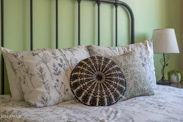a bed sitting in a bedroom next to a window and a lamp