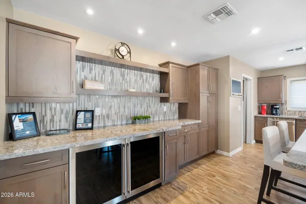 a kitchen with a sink dishwasher a refrigerator and cabinets with wooden floor