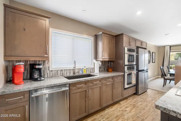 a kitchen with stainless steel appliances granite countertop a sink stove and refrigerator