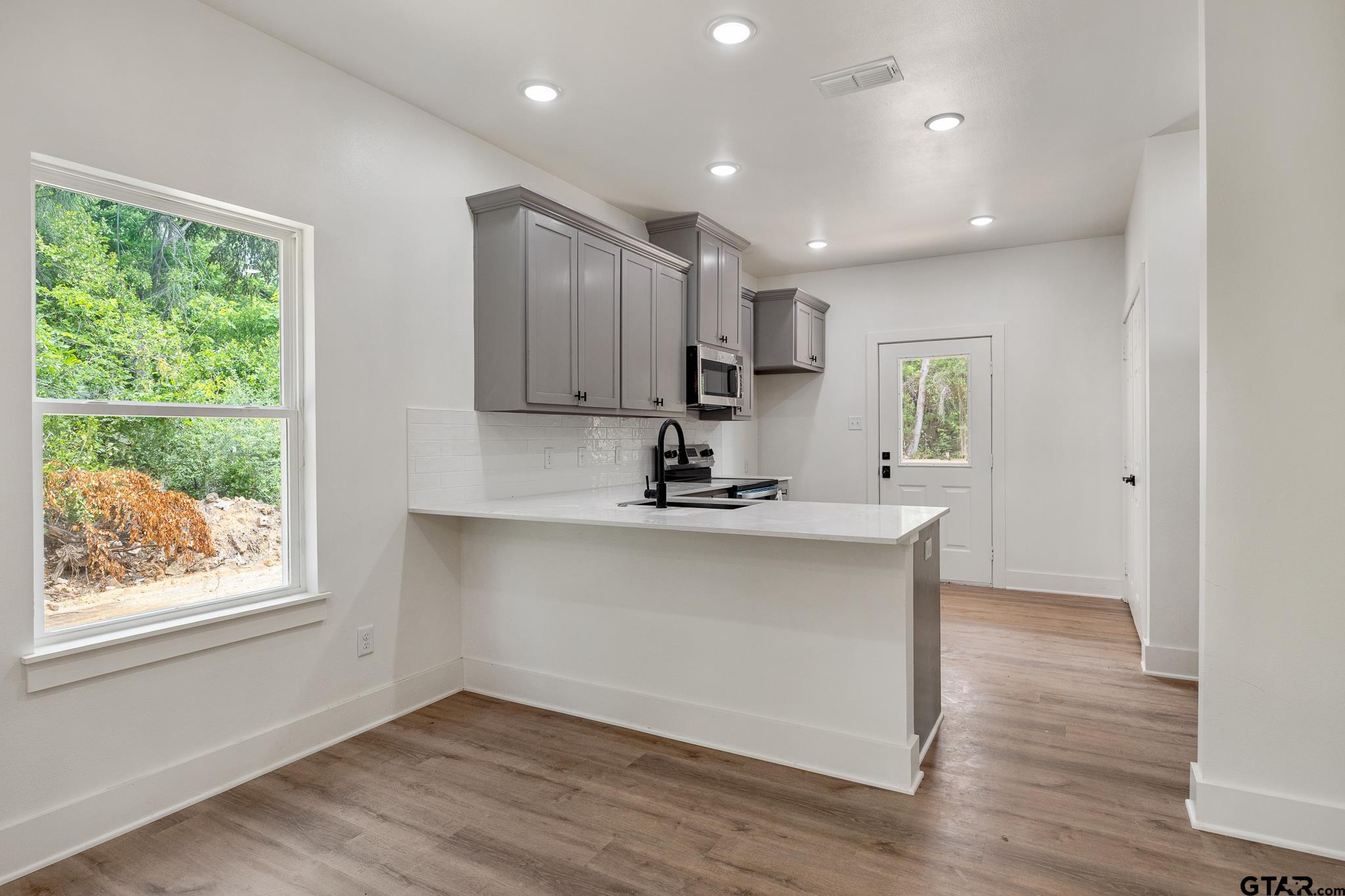 726 Boyd Avenue Tyler, TX 75701 - Photo 11 of 28 a view of kitchen with wooden floor and window