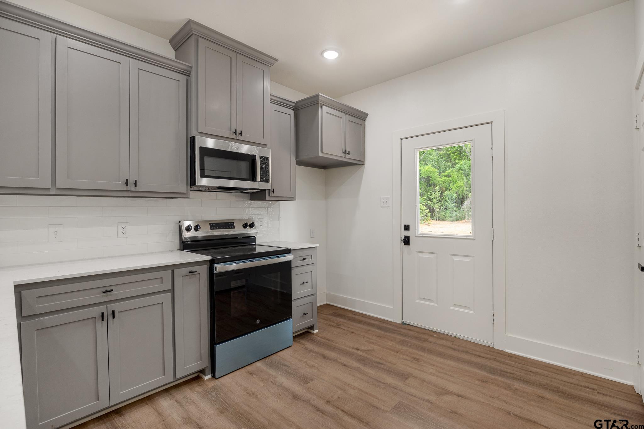 726 Boyd Avenue Tyler, TX 75701 - Photo 12 of 28 a kitchen with cabinets stainless steel appliances and wooden floor