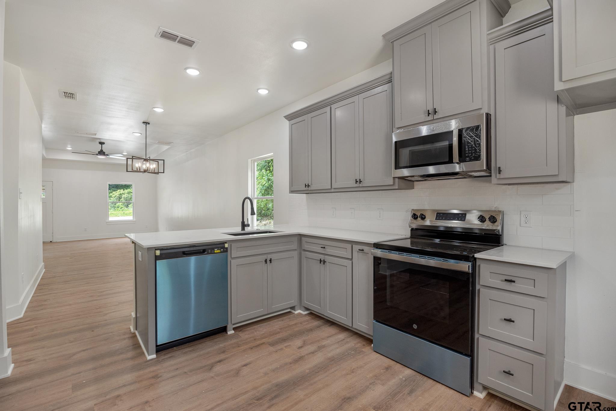 726 Boyd Avenue Tyler, TX 75701 - Photo 13 of 28 a kitchen with granite countertop a sink cabinets and stainless steel appliances