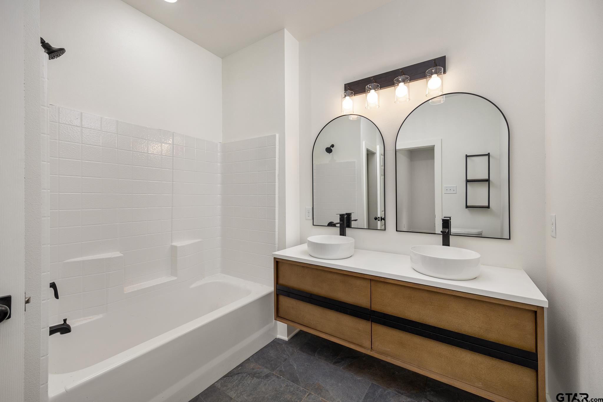 726 Boyd Avenue Tyler, TX 75701 - Photo 19 of 28 a bathroom with a tub sink and mirror