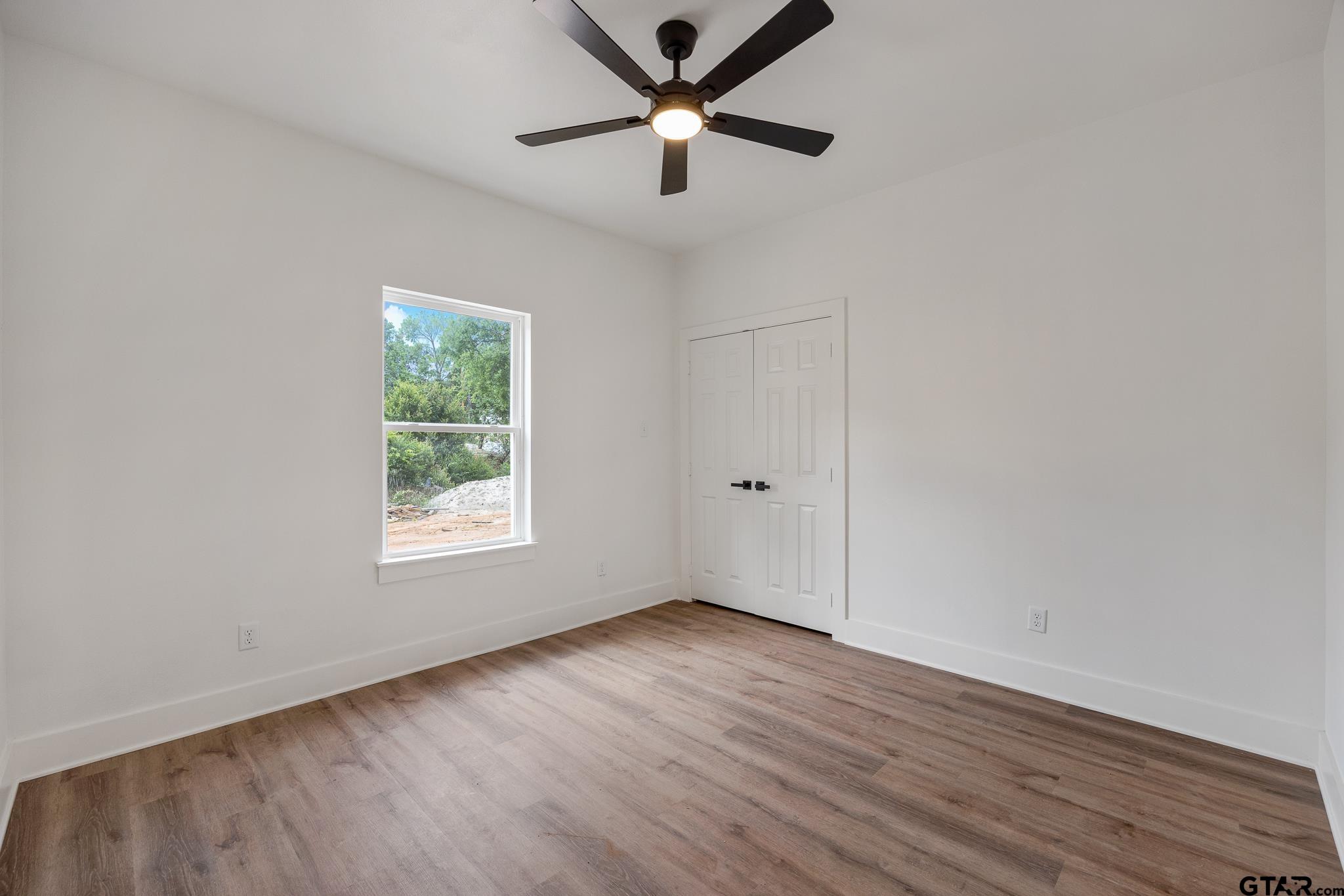 726 Boyd Avenue Tyler, TX 75701 - Photo 23 of 28 an empty room with wooden floor and windows