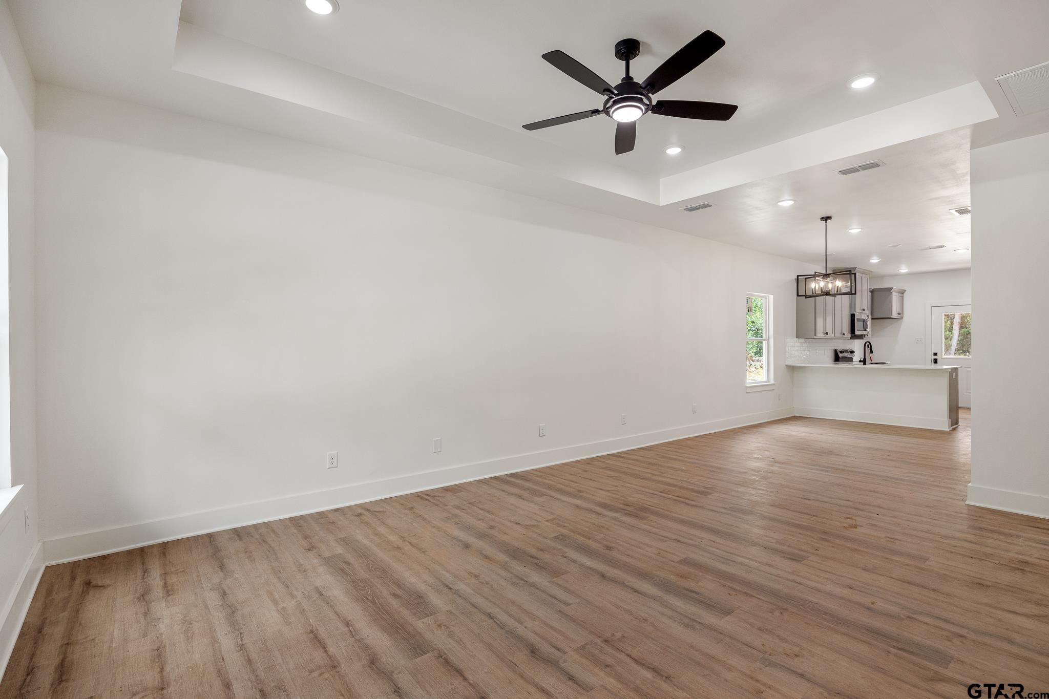 726 Boyd Avenue Tyler, TX 75701 - Photo 5 of 28 an empty room with wooden floor and a ceiling fan