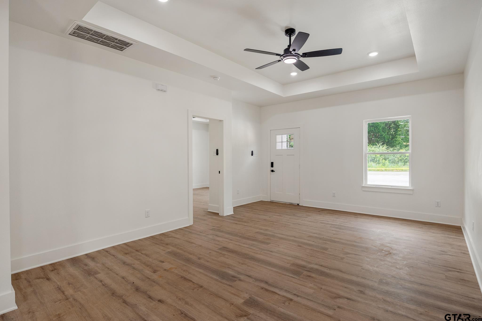 726 Boyd Avenue Tyler, TX 75701 - Photo 7 of 28 wooden floor in an empty room with a ceiling fan