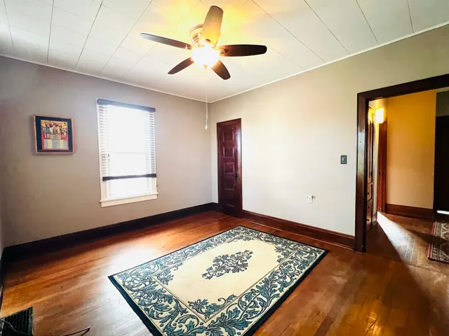 a view of an empty room with window and rug