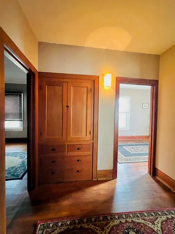 a view of a hallway with wooden floor and closet