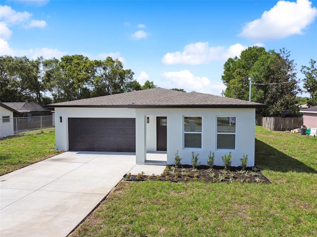 7453 Blackhawk Trail Spring Hill, FL 34606 - Photo 1 of 1 a front view of house with yard and trees in the background