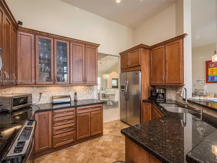a kitchen with stainless steel appliances granite countertop a sink stove and refrigerator