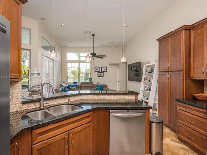 a kitchen with stainless steel appliances granite countertop a sink a counter space and refrigerator