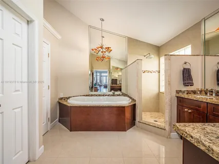 a spacious bathroom with a granite countertop sink a mirror and a shower