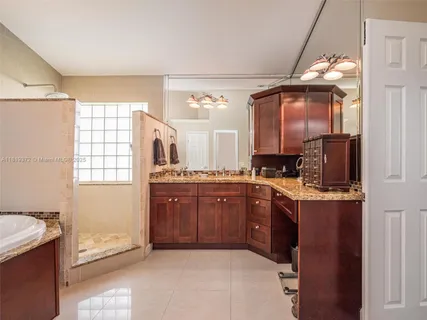a spacious bathroom with a granite countertop sink mirror and a bathtub