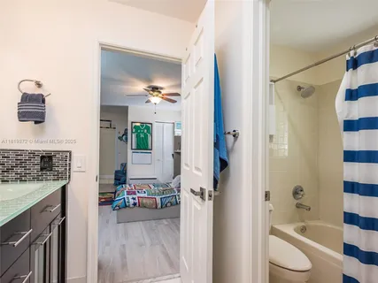 a spacious bathroom with a granite countertop sink a mirror a bathtub and shower