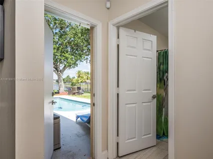 a view of a hallway with wooden floor and a dining room