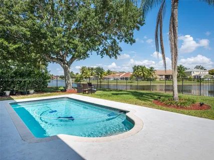 a view of swimming pool with a garden and trees