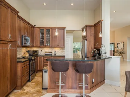 a kitchen with stainless steel appliances granite countertop wooden cabinets a stove top oven a sink and dishwasher