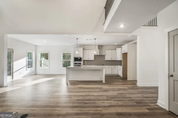 a kitchen with kitchen island a counter top space a sink refrigerator and cabinets