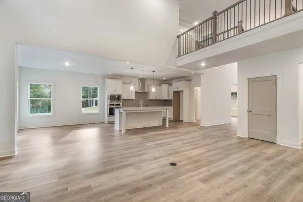 a kitchen with stainless steel appliances granite countertop a refrigerator a stove a sink dishwasher a oven with white cabinets and wooden floor