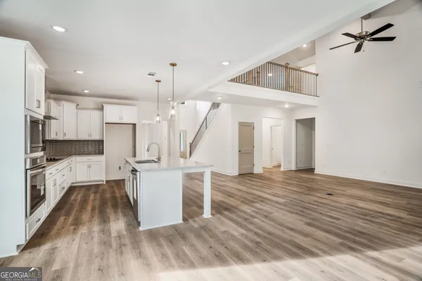 a view of kitchen with refrigerator and wooden floor