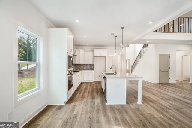 a large kitchen with kitchen island a sink stainless steel appliances and cabinets