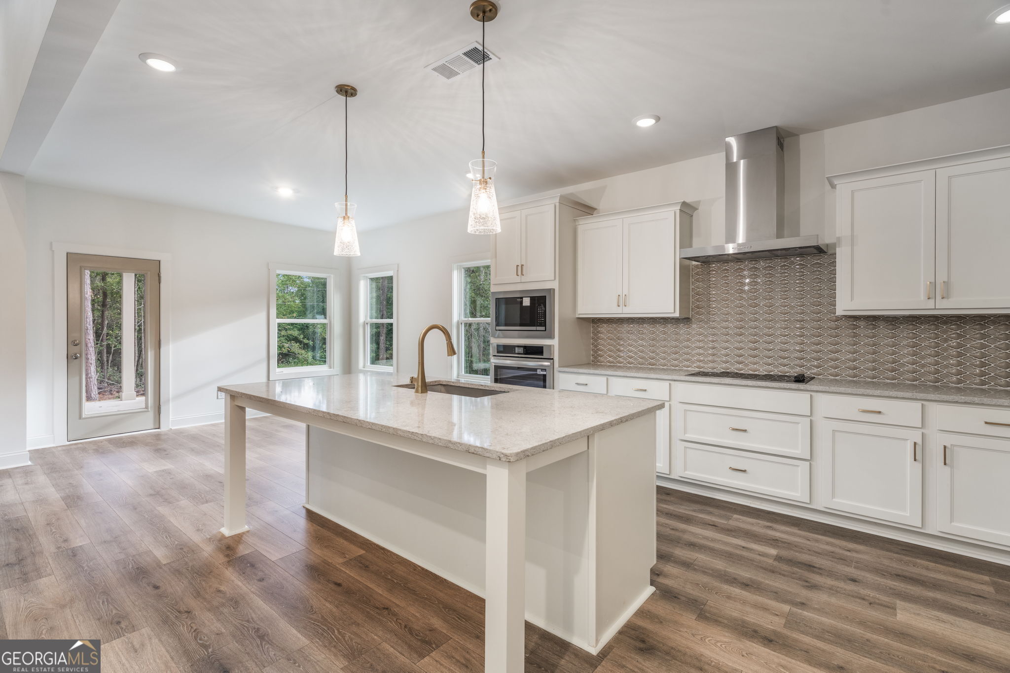 106 Mill Race Road Thomaston, GA 30286 - Photo 19 of 63 a kitchen with stainless steel appliances granite countertop a sink a stove and a wooden floor
