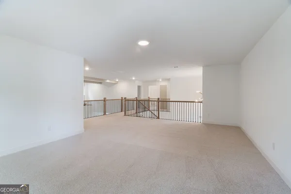 a view of an empty room and kitchen
