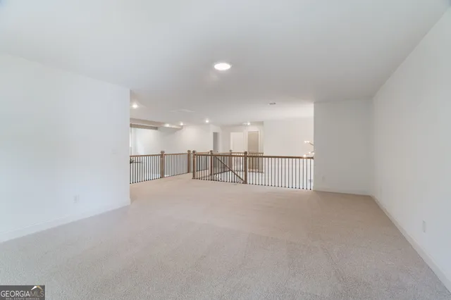 a view of an empty room and kitchen