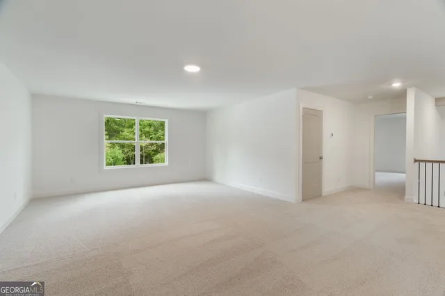 a view of an empty room and a kitchen