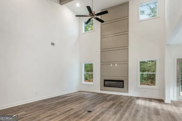 an empty room with windows and fireplace