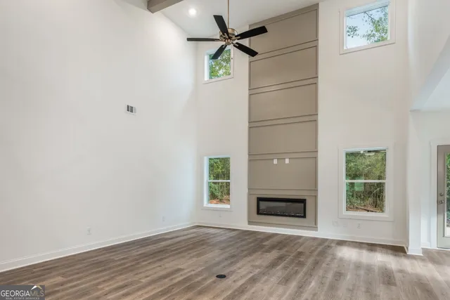 an empty room with windows and fireplace