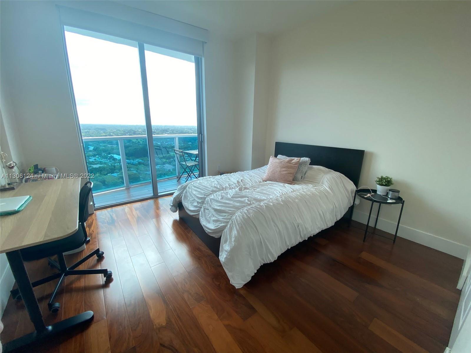 2681 North Flamingo Road, Unit 1905S Sunrise, FL 33323 - Photo 22 of 24 a bedroom with a bed window and wooden floor