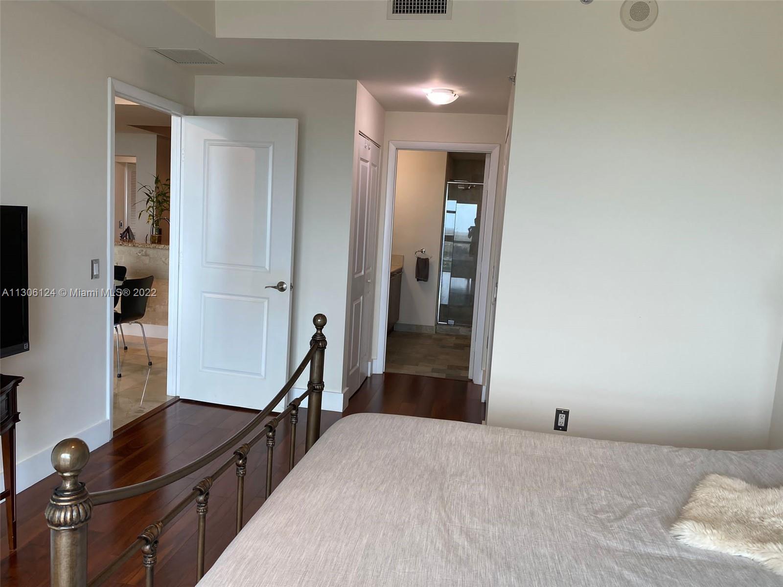 2681 North Flamingo Road, Unit 1905S Sunrise, FL 33323 - Photo 23 of 24 a bedroom with a bed and a flat tv screen on a dresser
