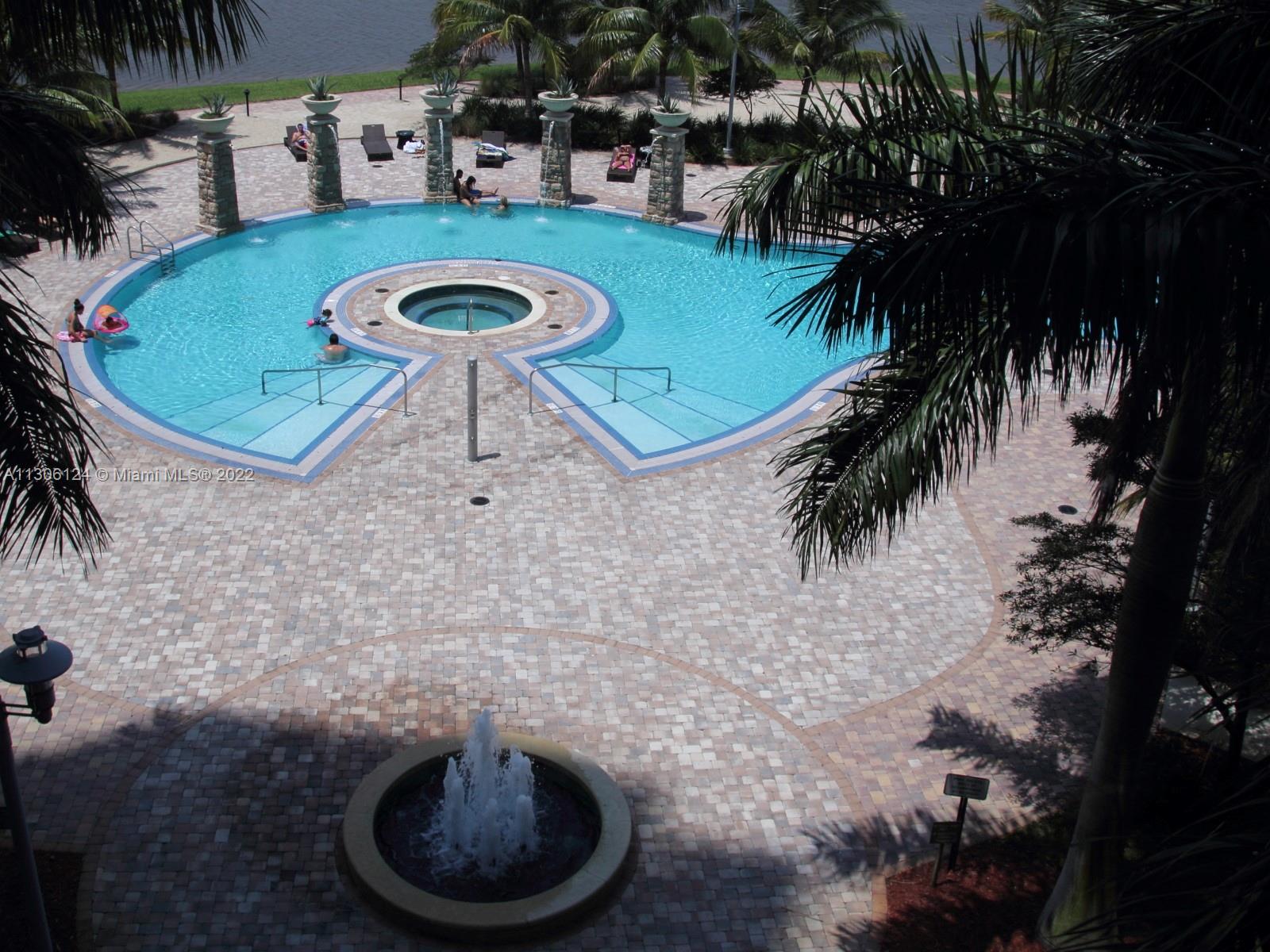 2681 North Flamingo Road, Unit 1905S Sunrise, FL 33323 - Photo 9 of 24 a view of a swimming pool with lawn chairs under an umbrella