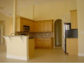 9053 Bronco Court Naples, FL 34113 - Photo 3 of 7 a kitchen with stainless steel appliances a refrigerator and a stove