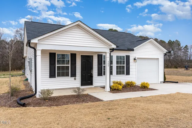 a front view of a house with a garden and plants