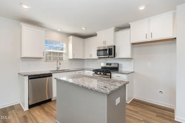 a kitchen with granite countertop a sink stove and cabinets